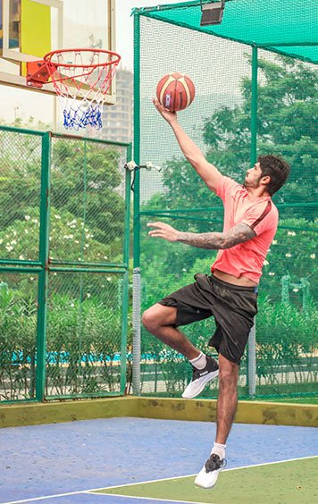 Student playing basketball on the campus court