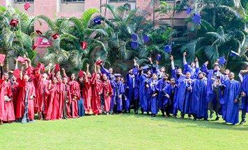 Graduating students celebrating on the lawn